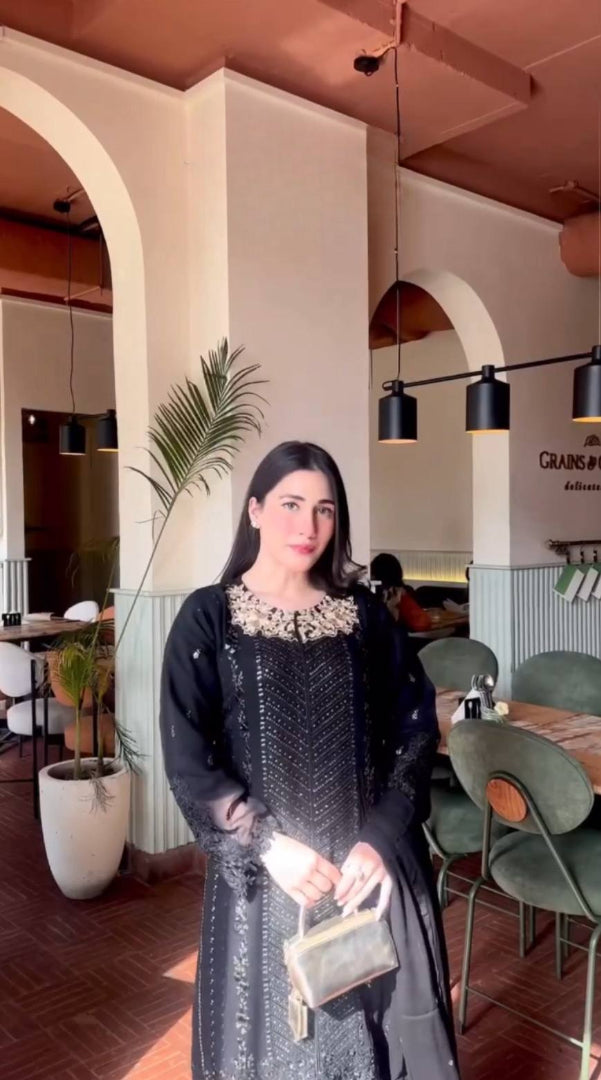A Captivating Woman in a Black Dress Gracing the Ambiance